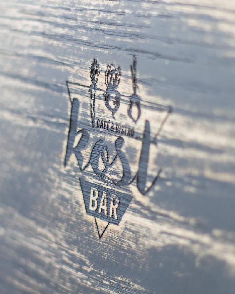 Eingraviertes Kost Bar Café & Bistro Logo auf Holz
