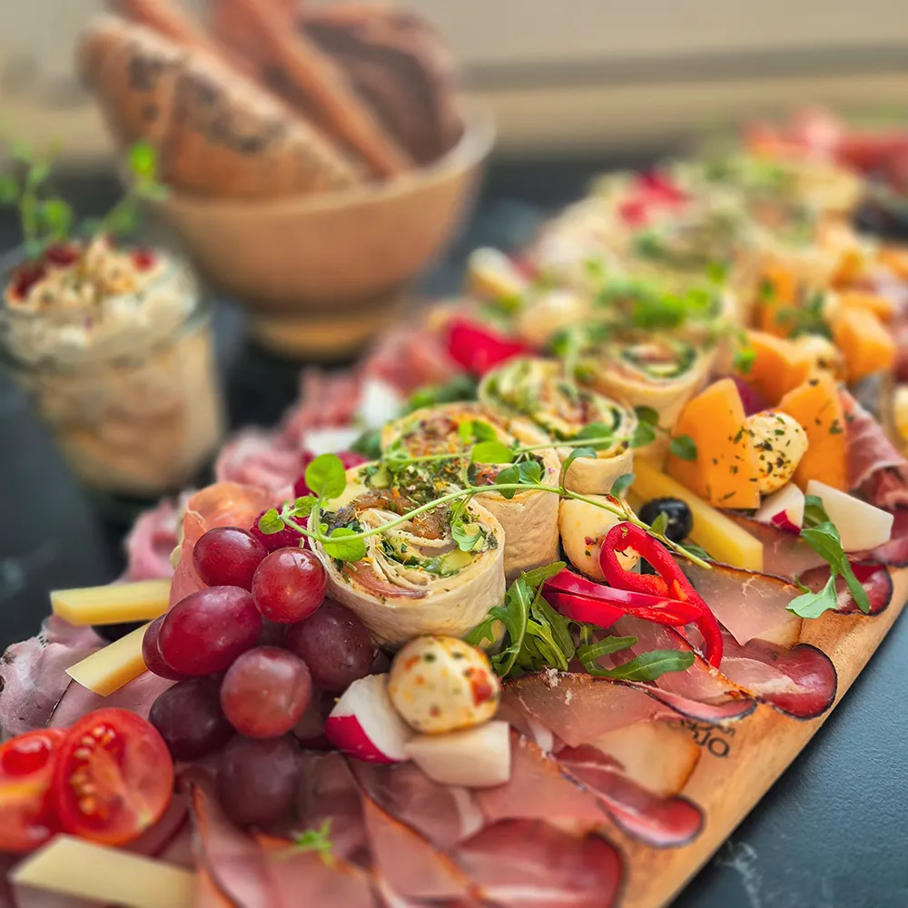 Kostbarkeiten Catering Oberkärnten – rustikale Jausenplatte mit Aufschnitt, Wraps, Weintrauben und frischem Gemüse von Irina Kanzian