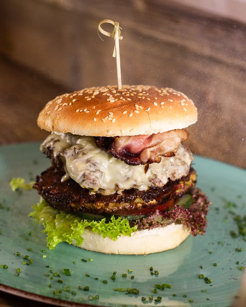 Saftiger Burger mit Käse und Speck auf Teller